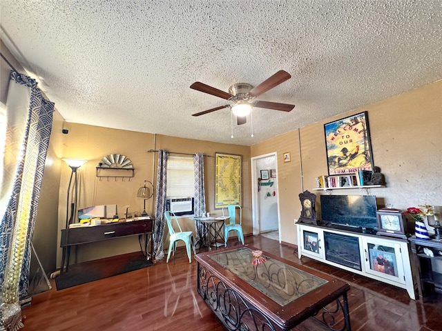 living area featuring cooling unit, dark wood-style flooring, ceiling fan, and a textured ceiling