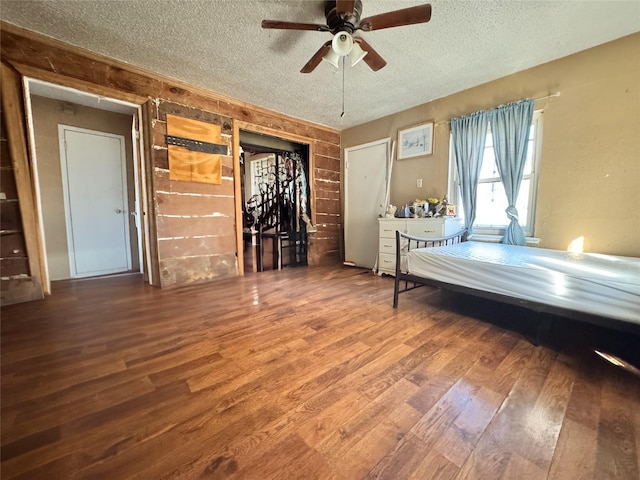 unfurnished bedroom with a ceiling fan, a textured ceiling, and wood finished floors