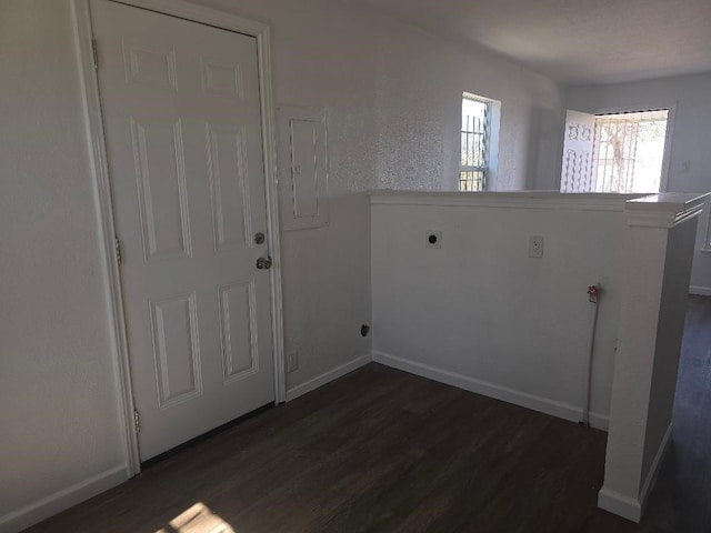 laundry room featuring dark wood-style floors, electric dryer hookup, laundry area, electric panel, and baseboards