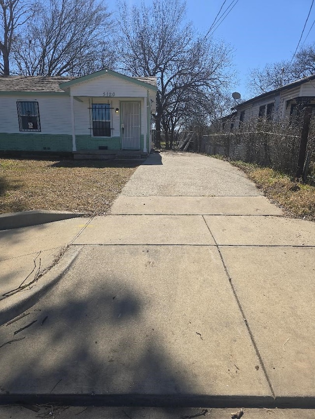 view of side of home featuring a porch and fence