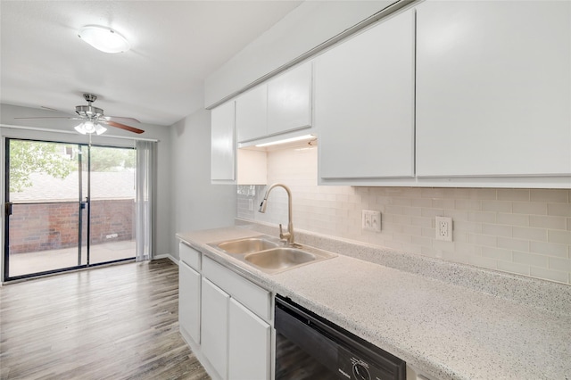 kitchen featuring tasteful backsplash, white cabinets, dishwasher, light wood-type flooring, and a sink