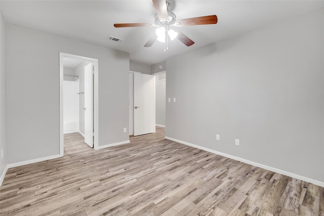 unfurnished bedroom with a ceiling fan, visible vents, light wood-style flooring, and baseboards