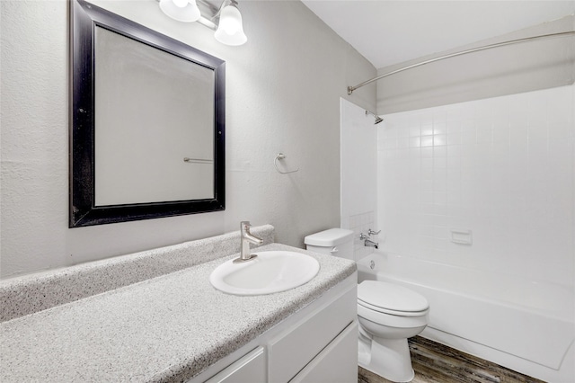 bathroom featuring  shower combination, vanity, toilet, and wood finished floors