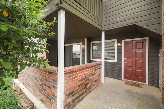 doorway to property featuring brick siding