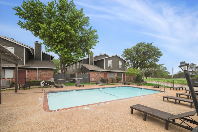 pool featuring a patio area and fence