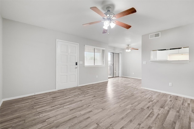 empty room featuring ceiling fan, light wood-style flooring, visible vents, and baseboards