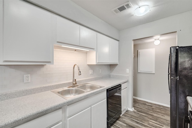 kitchen with visible vents, light countertops, black appliances, white cabinetry, and a sink