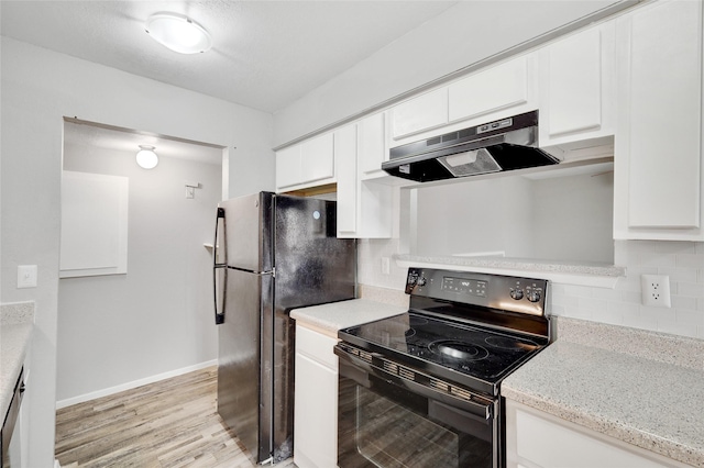 kitchen featuring under cabinet range hood, white cabinetry, light wood-type flooring, backsplash, and black appliances