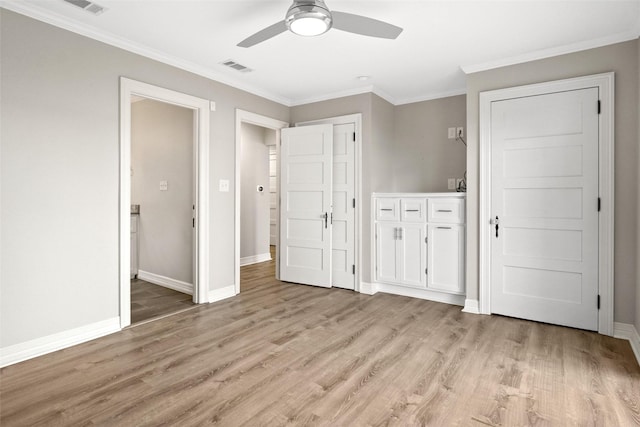 unfurnished bedroom featuring crown molding, visible vents, light wood-style flooring, a ceiling fan, and baseboards