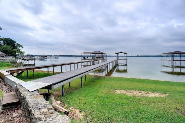 view of dock featuring a water view, a lawn, and boat lift