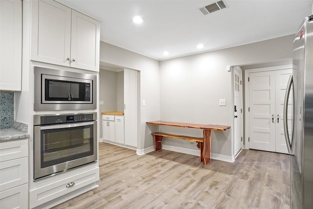 kitchen with visible vents, white cabinets, stainless steel appliances, light wood-style floors, and recessed lighting