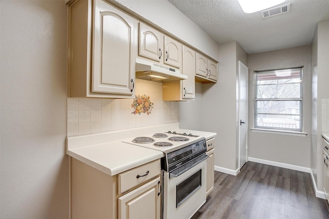 kitchen with dark wood finished floors, decorative backsplash, light countertops, under cabinet range hood, and white range with electric cooktop