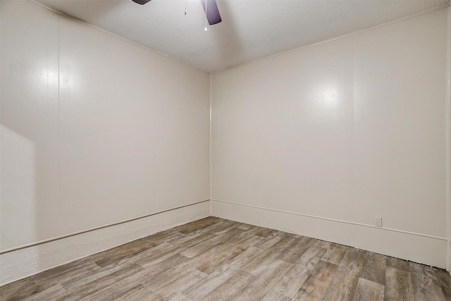 spare room featuring a textured ceiling, a ceiling fan, and wood finished floors