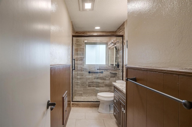 full bath featuring a textured ceiling, tile patterned flooring, toilet, vanity, and a stall shower