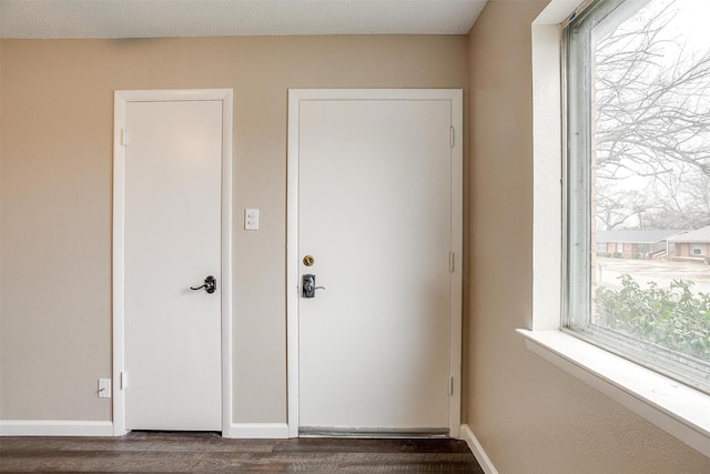 doorway to outside with baseboards and dark wood finished floors