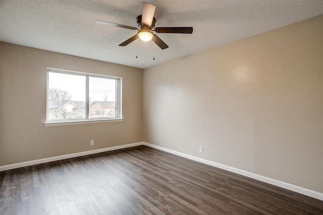 empty room featuring ceiling fan, baseboards, dark wood finished floors, and a textured ceiling