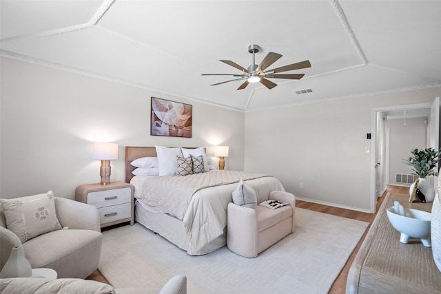 bedroom with visible vents, light wood-style floors, vaulted ceiling, attic access, and crown molding