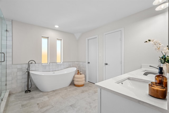 bathroom with double vanity, a freestanding tub, a sink, and a shower stall