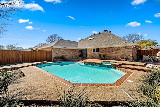 view of swimming pool featuring a patio area, a fenced backyard, and a pool with connected hot tub