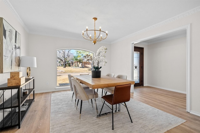 dining room featuring light wood finished floors, baseboards, and a notable chandelier