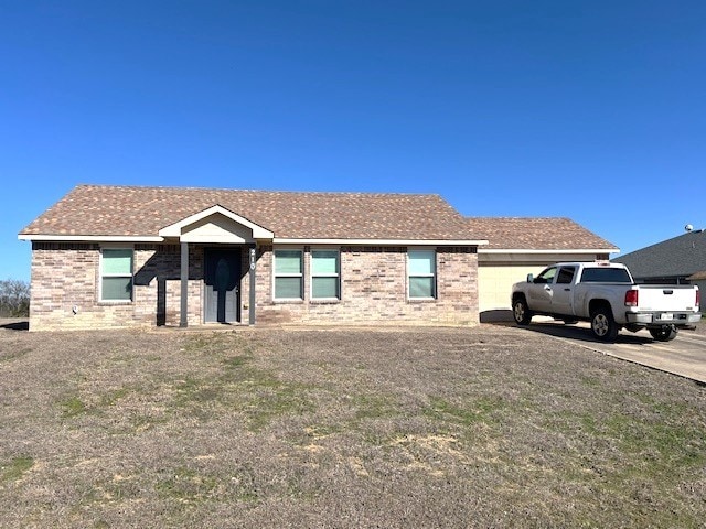 ranch-style house with a garage, driveway, brick siding, and a front yard