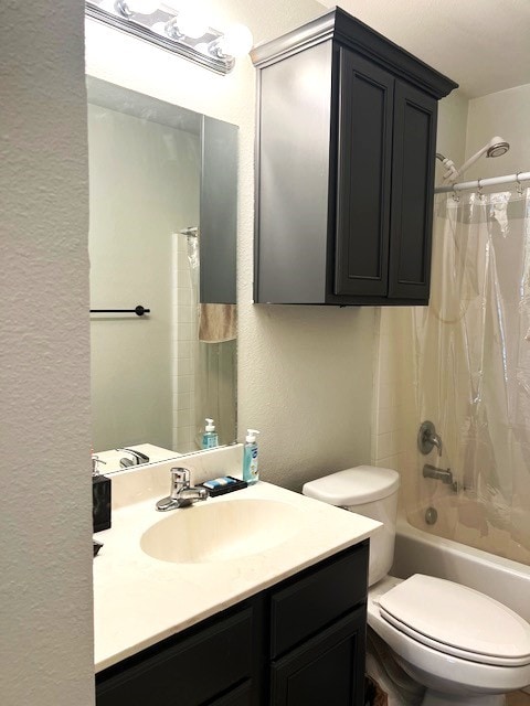 bathroom with toilet, a textured wall, shower / tub combo with curtain, and vanity