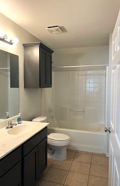 full bathroom with toilet, tile patterned floors, a textured ceiling, vanity, and washtub / shower combination