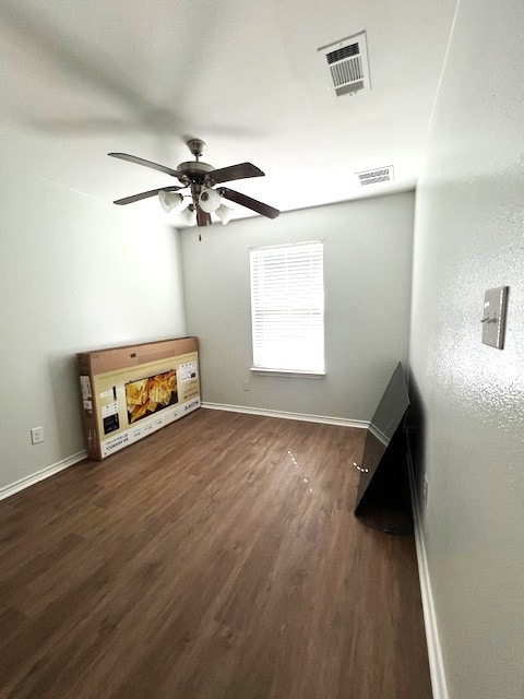 interior space with dark wood-style floors, visible vents, and baseboards