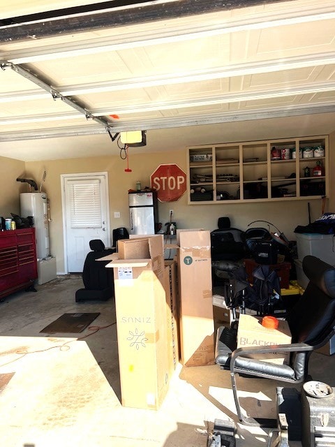 garage with water heater and freestanding refrigerator