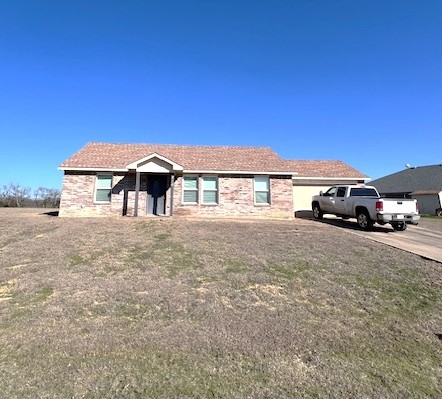 ranch-style home featuring a garage, a front yard, and driveway