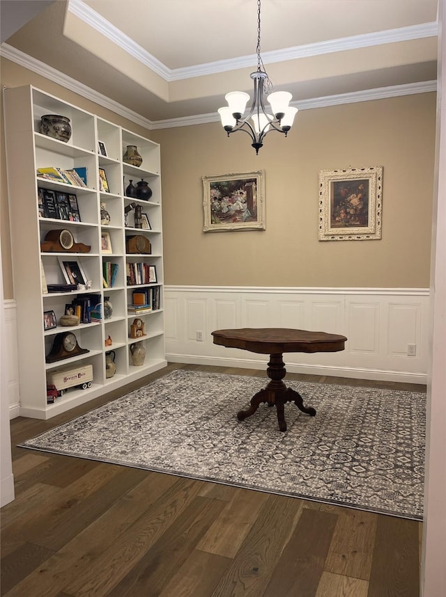 home office featuring a raised ceiling, wood finished floors, and wainscoting