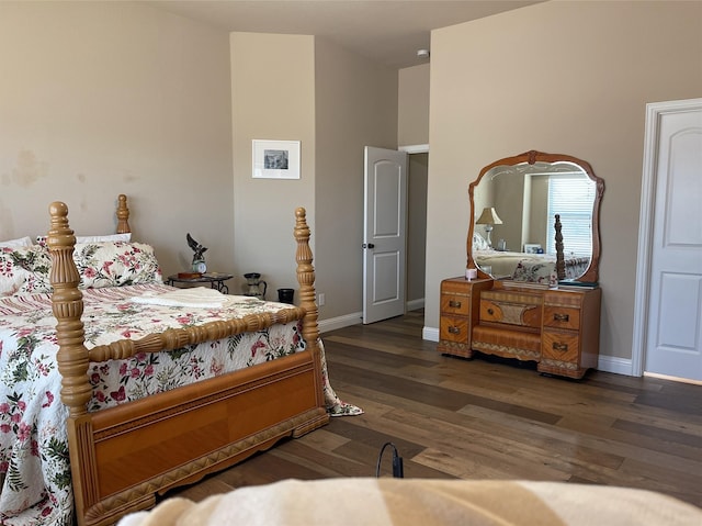 bedroom with dark wood-type flooring and baseboards