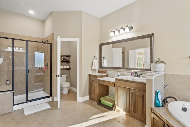 bathroom featuring a garden tub, a shower stall, toilet, and vanity