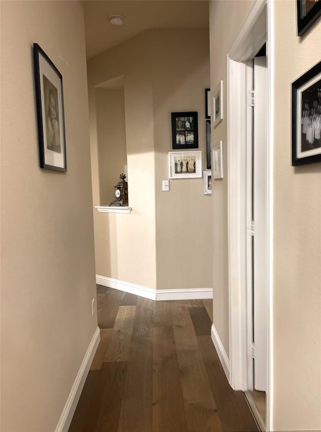 hallway with dark wood-style floors and baseboards