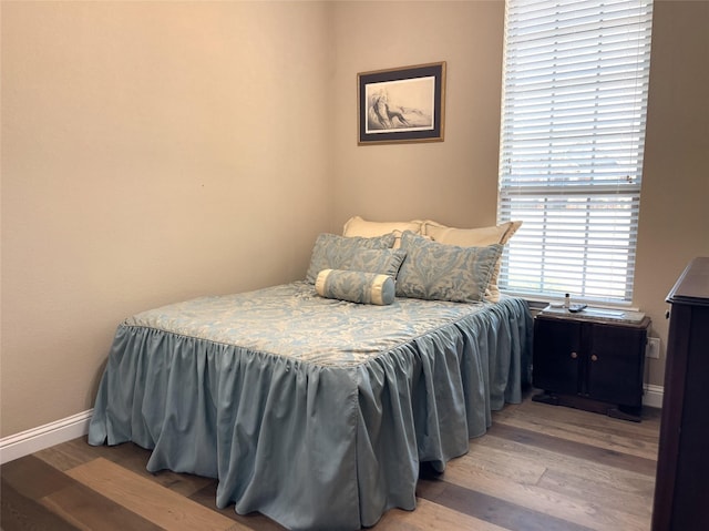 bedroom with baseboards and wood finished floors