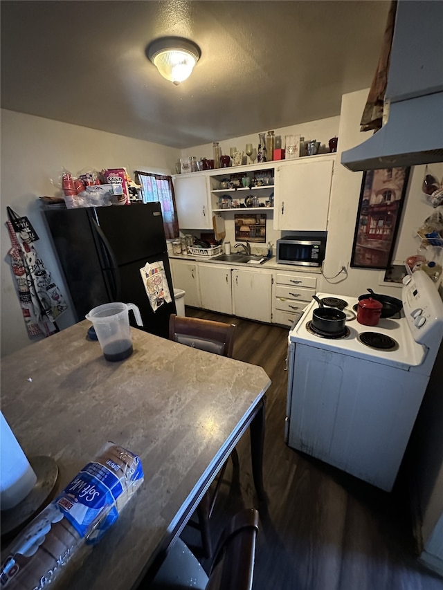 kitchen featuring open shelves, stainless steel microwave, freestanding refrigerator, white cabinetry, and extractor fan