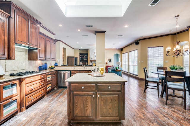 kitchen with pendant lighting, dark wood-style flooring, decorative backsplash, appliances with stainless steel finishes, and a peninsula