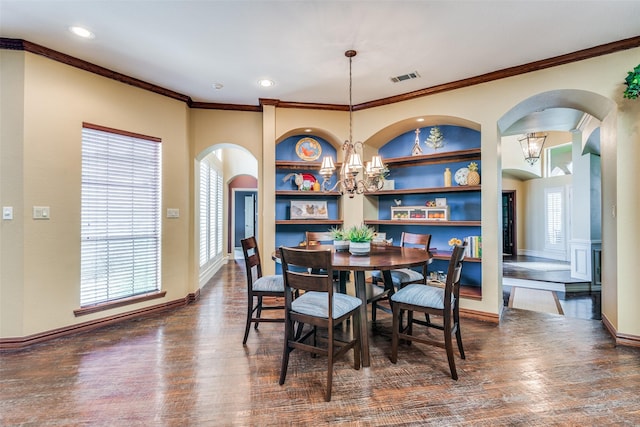 dining space with built in features, arched walkways, an inviting chandelier, dark wood-type flooring, and ornamental molding