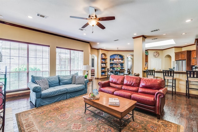 living room featuring dark wood-type flooring, arched walkways, and visible vents