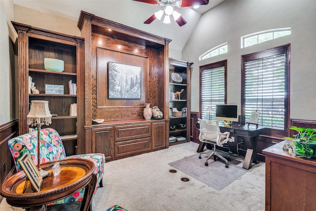 office area featuring a wealth of natural light, wainscoting, light colored carpet, and vaulted ceiling