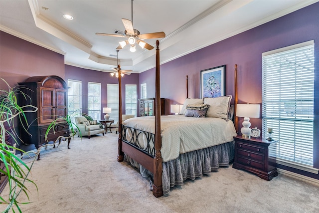 bedroom with ceiling fan, light colored carpet, visible vents, ornamental molding, and a tray ceiling