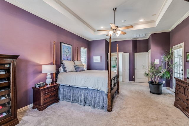 bedroom featuring ornamental molding, a tray ceiling, light colored carpet, and visible vents