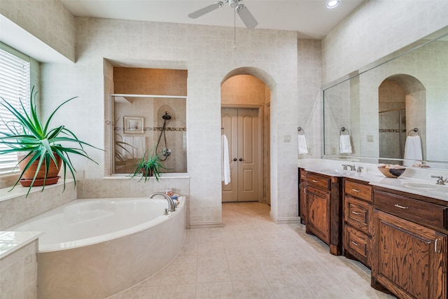 full bathroom featuring a garden tub, double vanity, a stall shower, a sink, and tile patterned flooring