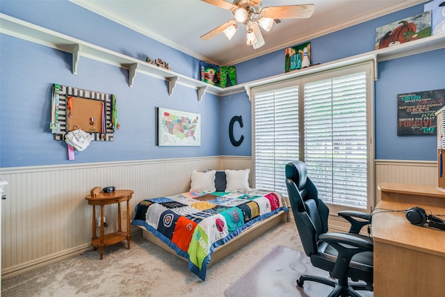 bedroom with light carpet, a wainscoted wall, a ceiling fan, and crown molding