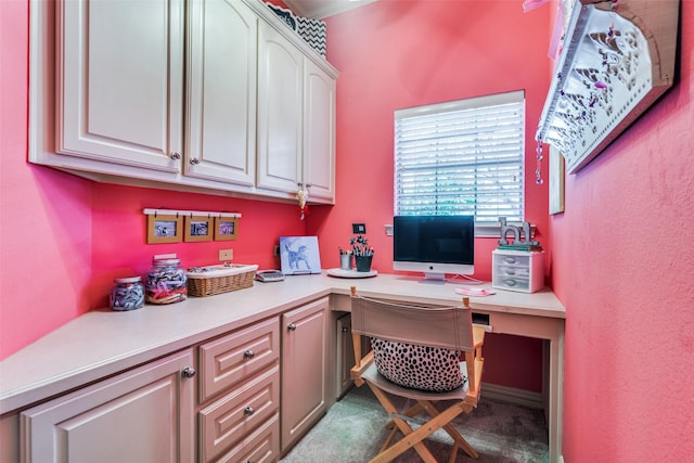 home office featuring dark colored carpet and built in desk