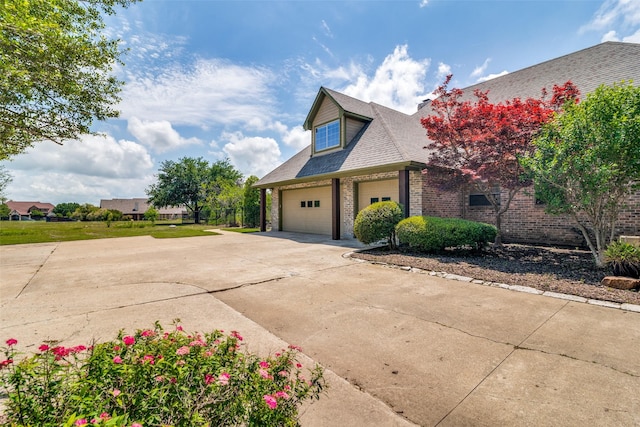 view of side of home with concrete driveway, brick siding, and roof with shingles