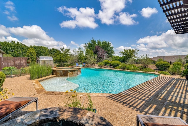 view of swimming pool with a pool with connected hot tub and fence