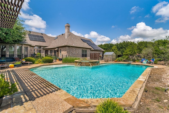 view of swimming pool with a diving board, fence, and a pool with connected hot tub