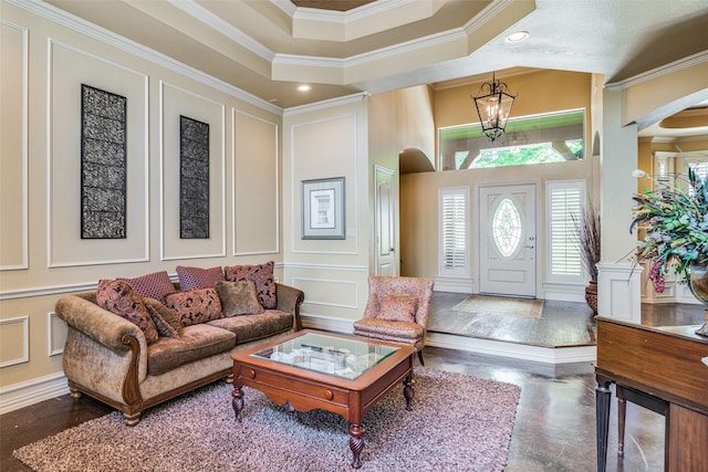 foyer with arched walkways, a towering ceiling, crown molding, a chandelier, and a decorative wall