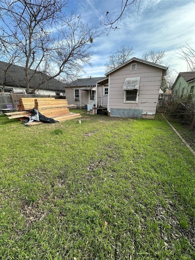 rear view of house featuring a lawn, a wooden deck, and fence